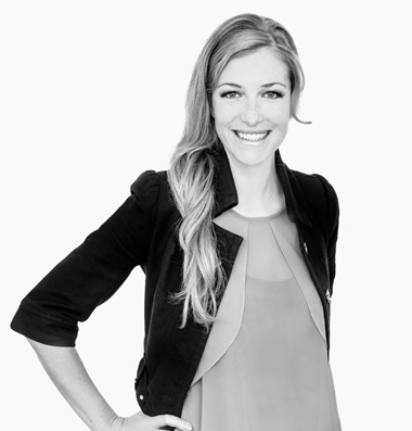 GET | Team Silke Scherer Frau in schwarzem Blazer lacht mit Hand in der Hüfte in die Kamera