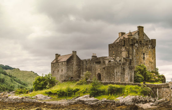 GET | Sprachreise in Schottland Burgähnliches Steinhaus in grüner Berglandschaft